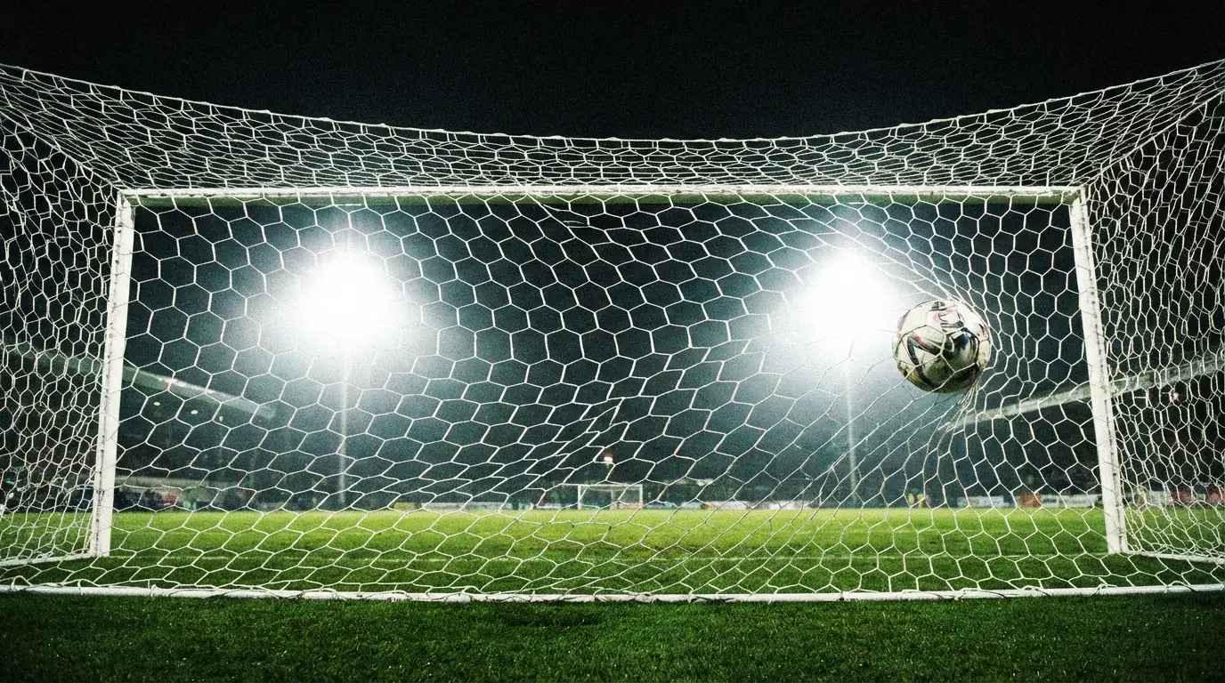 Red de portería de fútbol ondulando tras un gol con el balón dentro de la red