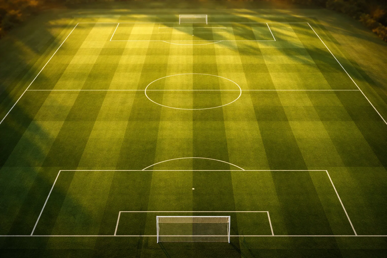 Tipos de apuestas de fútbol: vista cenital de un campo de fútbol con líneas de juego iluminadas